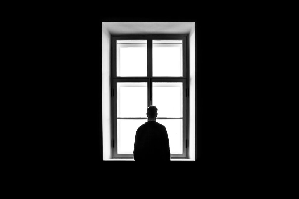 hombre mirando la ventana y pensativo
